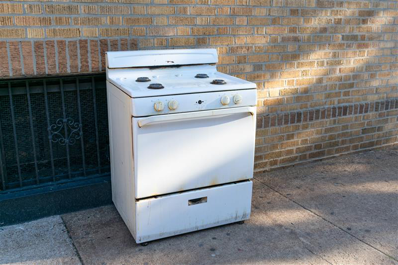 Older stove outside someone's house.